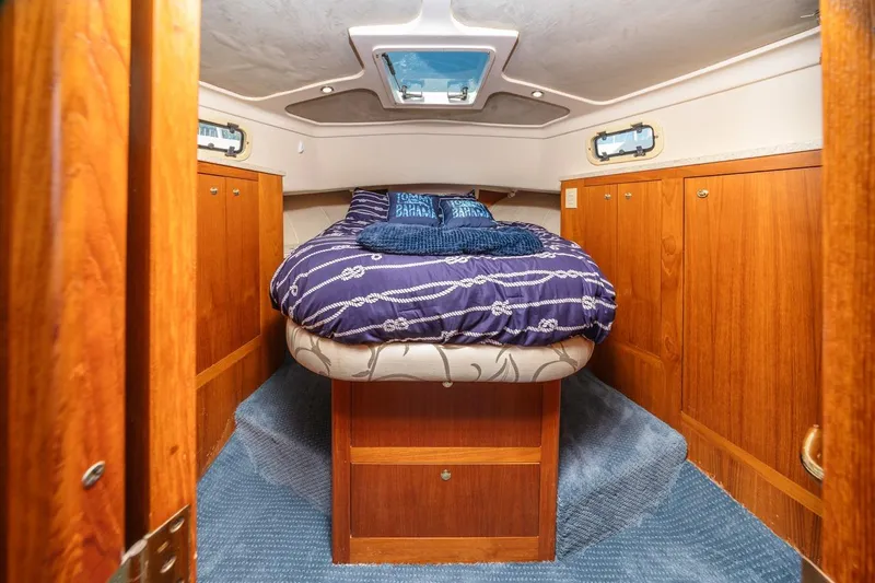 La Woman Yacht Photos Pics 2001 Mainship 390 Trawler cabin with cozy bed, wooden cabinets, and nautical decor.