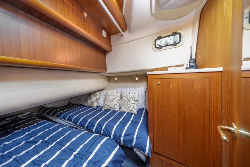 La Woman Yacht Photos Pics 2001 Mainship 390 Trawler cabin with twin beds, wooden cabinetry, and nautical decor.
