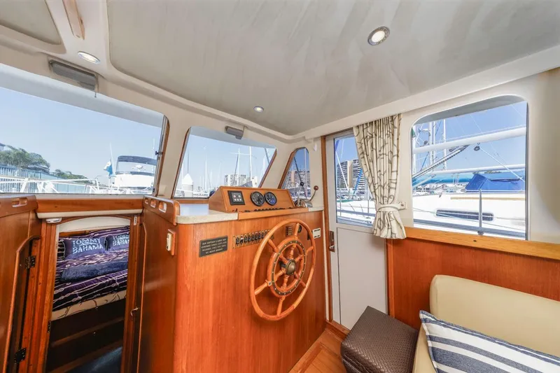 La Woman Yacht Photos Pics 2001 Mainship 390 Trawler interior with helm, wooden accents, and marina view.