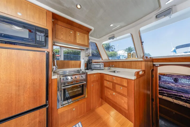 La Woman Yacht Photos Pics Interior of 2001 Mainship 390 Trawler kitchen with wood cabinetry and modern appliances.