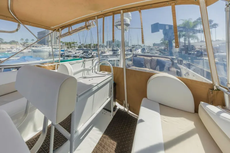La Woman Yacht Photos Pics 2001 Mainship 390 Trawler interior with marina view, featuring seating and helm area.