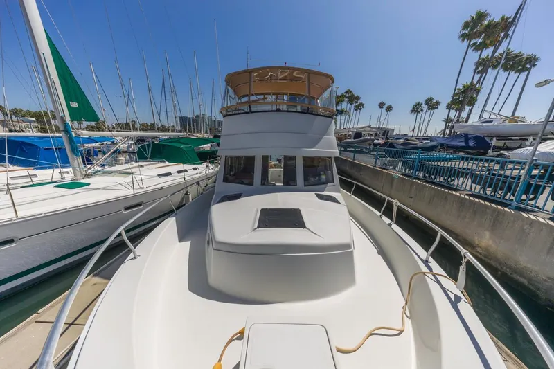 La Woman Yacht Photos Pics 2001 Mainship 390 Trawler docked at marina with sailboats and palm trees.