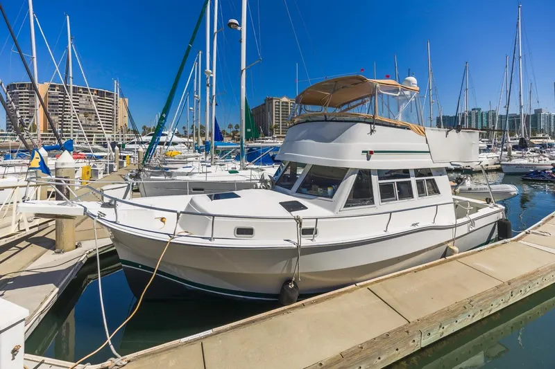 La Woman Yacht Photos Pics 2001 Mainship 390 Trawler docked in a marina with sailboats and buildings.