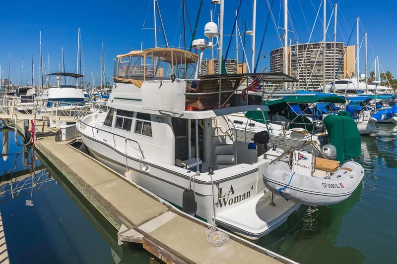 La Woman Yacht Photos Pics 2001 Mainship 390 Trawler docked at marina, surrounded by sailboats under clear blue sky.