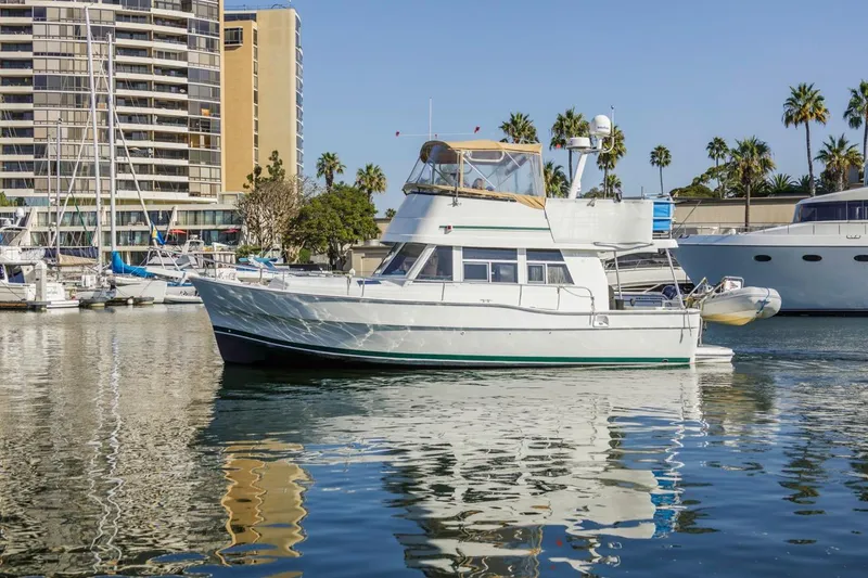 La Woman Yacht Photos Pics 2001 Mainship 390 Trawler docked in marina, surrounded by palm trees and buildings.