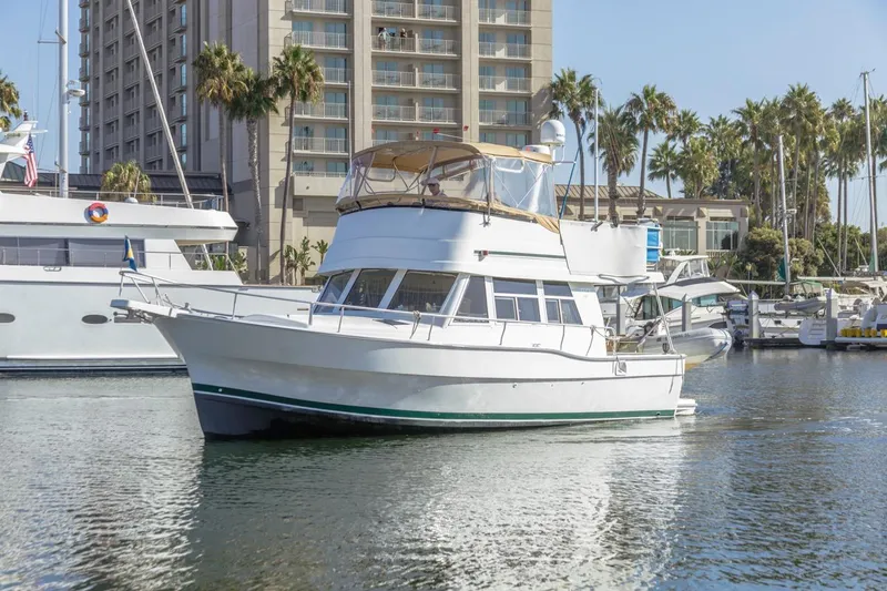La Woman Yacht Photos Pics 2001 Mainship 390 Trawler docked in marina, surrounded by palm trees and buildings.