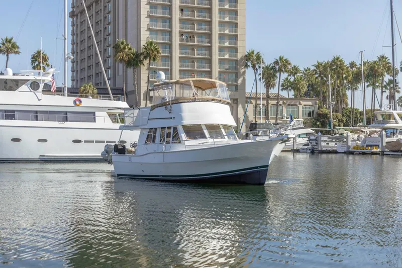 La Woman Yacht Photos Pics 2001 Mainship 390 Trawler in marina, surrounded by yachts and palm trees.