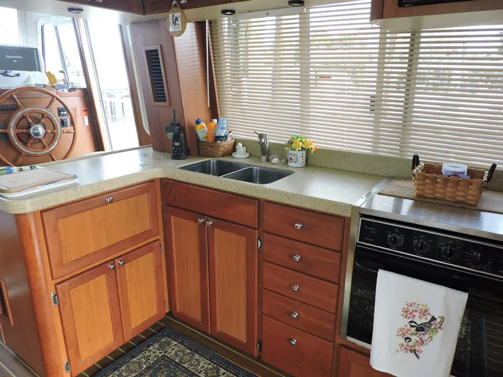 Angels Only Yacht Photos Pics 2007 Mainship 400 Trawler kitchen with wooden cabinets, dual sink, and stove.