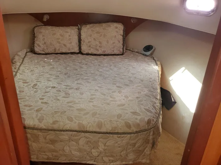 Angels Only Yacht Photos Pics 2007 Mainship 400 Trawler cabin with a cozy bed and decorative pillows.