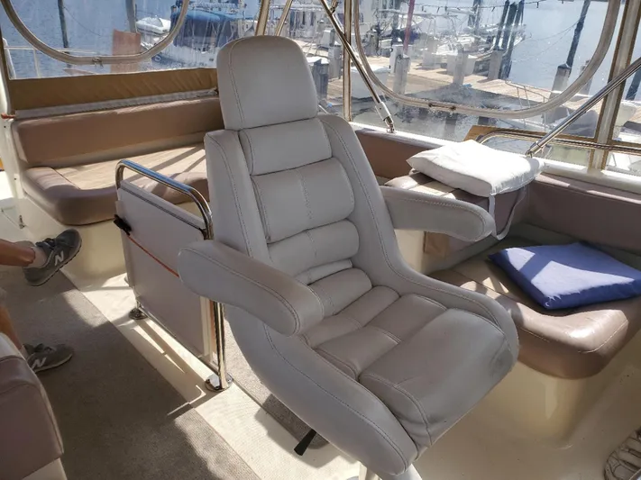 Angels Only Yacht Photos Pics Captain's chair on 2007 Mainship 400 Trawler, with marina view in background.