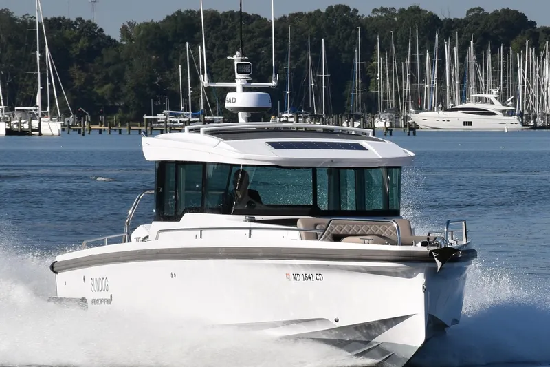 Sundog Yacht Photos Pics 2023 Axopar 37XC Wet Bar cruising on a scenic waterway with marina backdrop.