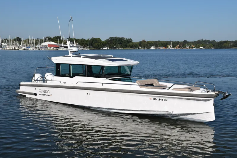 Sundog Yacht Photos Pics 2023 Axopar 37XC Wet Bar boat on calm water, featuring sleek design and modern amenities.