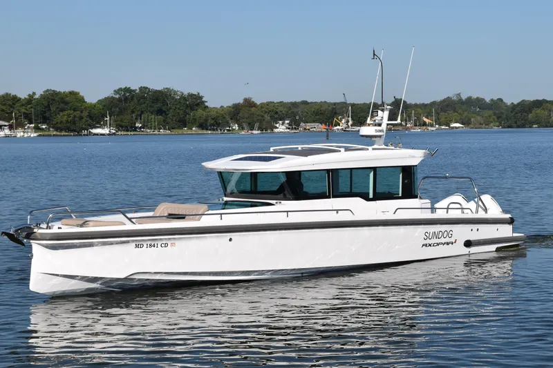 Sundog Yacht Photos Pics 2023 Axopar 37XC Wet Bar boat on calm water, featuring sleek design and modern amenities.