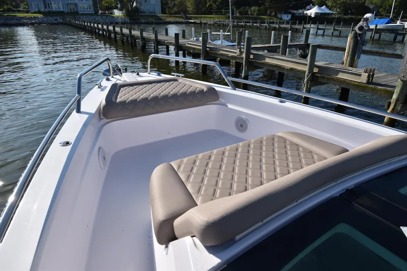Sundog Yacht Photos Pics 2023 Axopar 37XC Wet Bar boat with cushioned seating, docked by a serene waterfront.