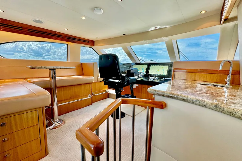 Red Queen Yacht Photos Pics Luxurious interior of 2008 Hatteras 64 Convertible yacht with helm, seating, and panoramic windows.