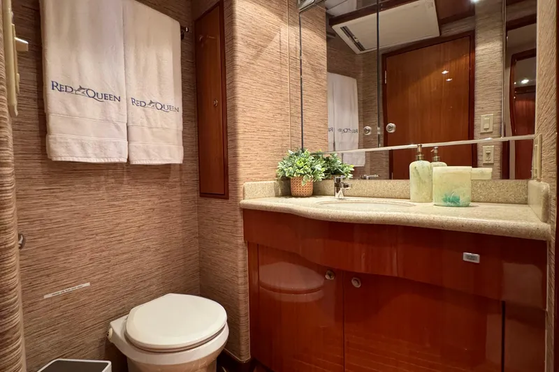 Red Queen Yacht Photos Pics Luxurious bathroom in 2008 Hatteras 64 Convertible yacht with elegant wood cabinetry and modern fixtures.