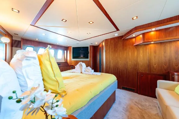  Yacht Photos Pics Luxurious bedroom interior on a 2009 Sunseeker 90 yacht, featuring elegant wood paneling and plush bedding.