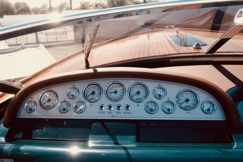  Yacht Photos Pics Dashboard of a 2003 Riva Aquariva 33 boat with vintage gauges and wooden accents.