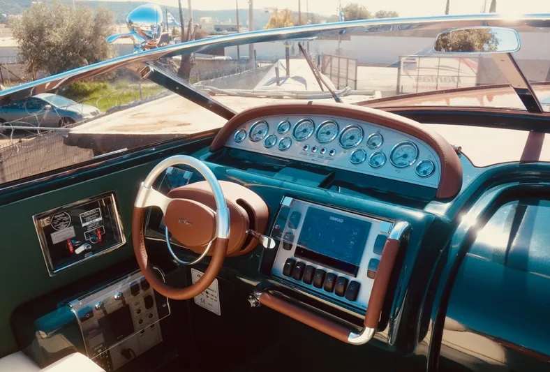  Yacht Photos Pics 2003 Riva Aquariva 33 dashboard with classic steering wheel and modern navigation instruments.