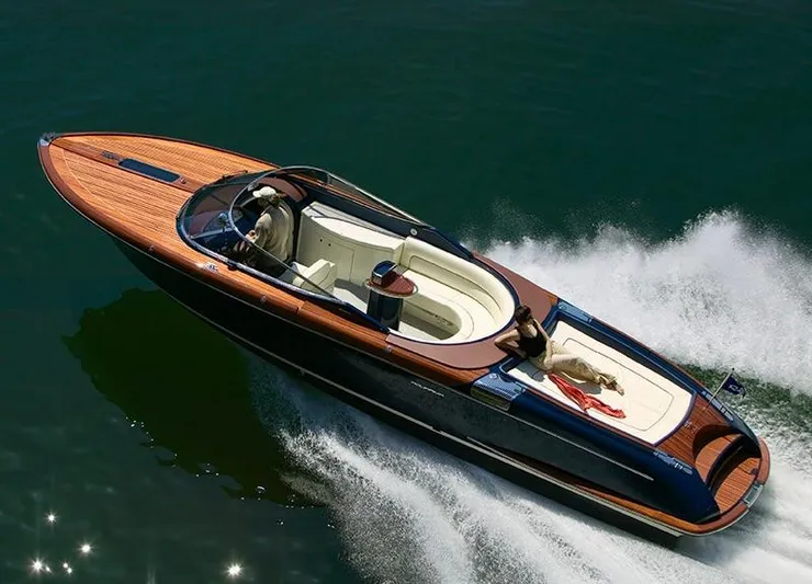  Yacht Photos Pics 2003 Riva Aquariva 33 speedboat cruising on water with a person relaxing onboard.