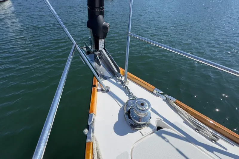 Finesse Yacht Photos Pics Bow of 2005 Sabre 386 sailboat with anchor chain and winch on calm water.