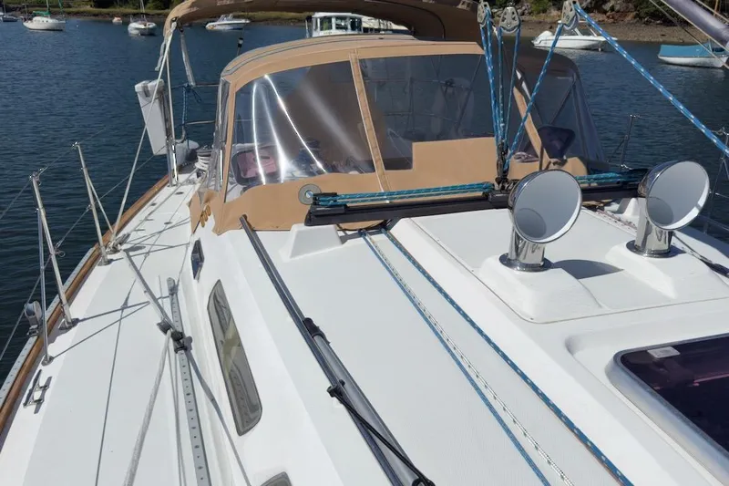 Finesse Yacht Photos Pics 2005 Sabre 386 sailboat deck with tan canopy, docked in a serene marina.