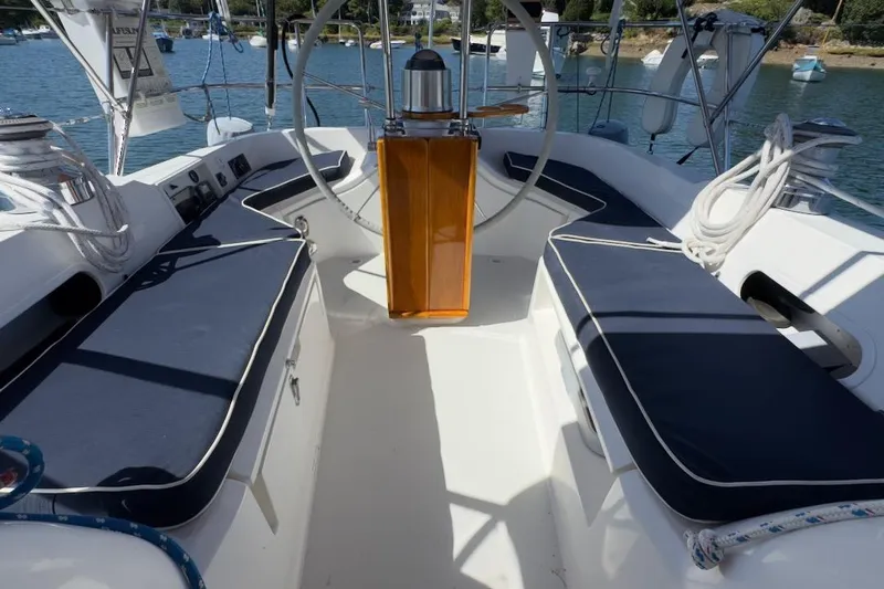 Finesse Yacht Photos Pics 2005 Sabre 386 sailboat cockpit with blue cushions and steering wheel, docked in a marina.