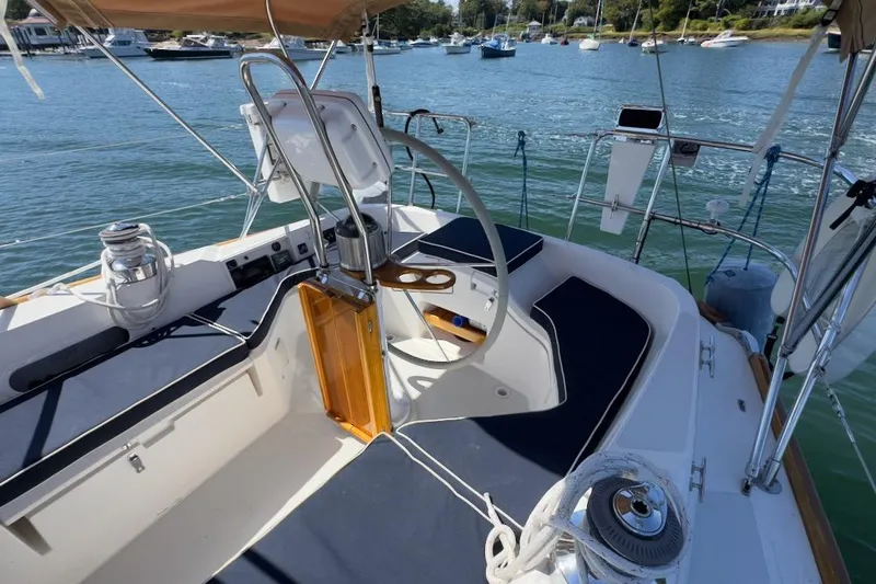 Finesse Yacht Photos Pics 2005 Sabre 386 sailboat cockpit with seating, steering wheel, and scenic marina view.