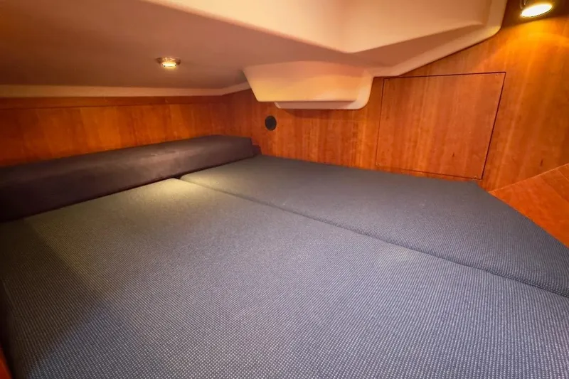 Finesse Yacht Photos Pics Interior cabin of 2005 Sabre 386 yacht with cozy bedding and wooden paneling.