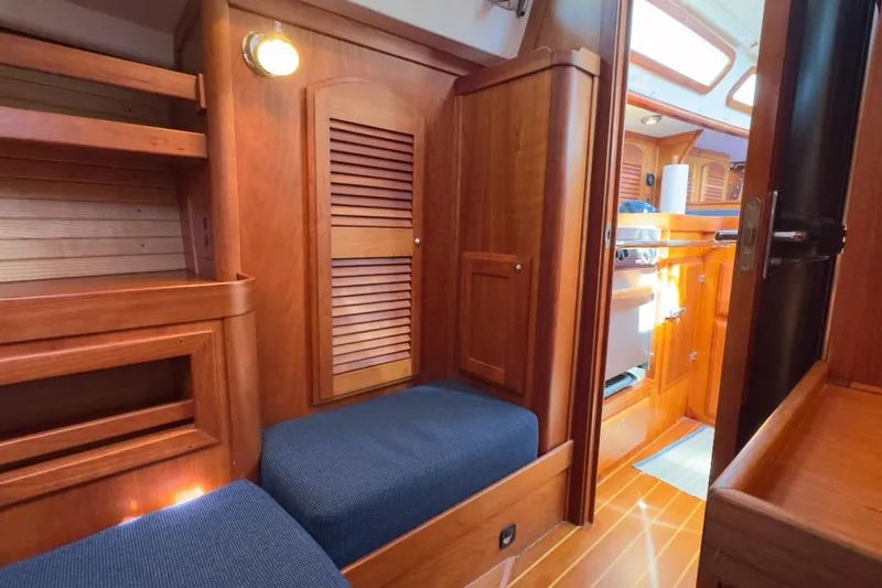 Finesse Yacht Photos Pics Interior of 2005 Sabre 386 sailboat with wooden cabinetry and blue seating.