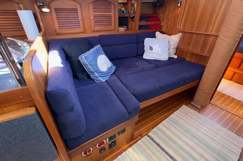 Finesse Yacht Photos Pics Luxurious Sabre 386 yacht interior with blue cushioned seating, wooden paneling, and decorative pillows.
