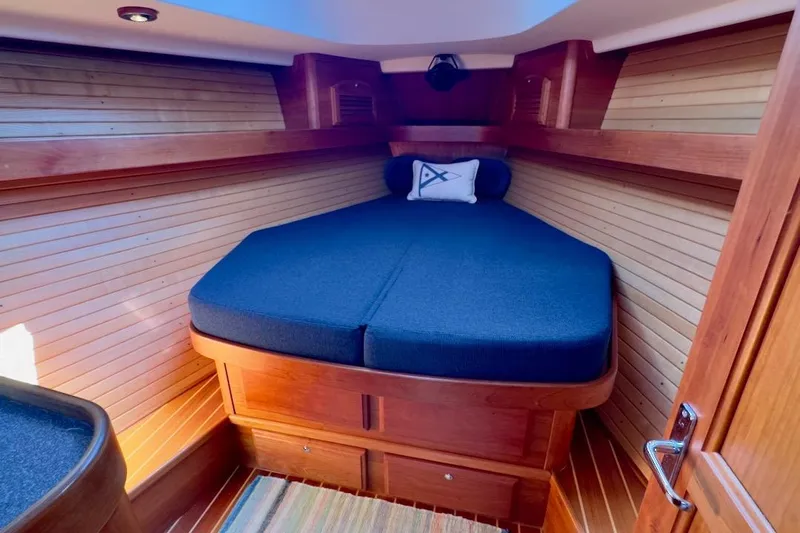 Finesse Yacht Photos Pics Cozy cabin interior of 2005 Sabre 386 sailboat with wooden finish and blue bedding.