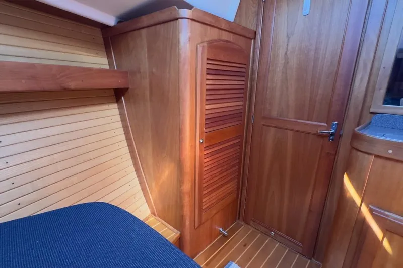 Finesse Yacht Photos Pics Interior of 2005 Sabre 386 sailboat with wooden cabinetry and blue upholstery.