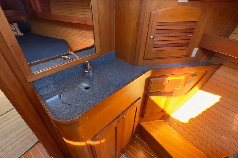 Finesse Yacht Photos Pics 2005 Sabre 386 yacht interior with wooden cabinetry and blue countertop sink.