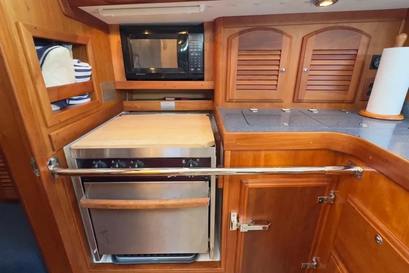 Finesse Yacht Photos Pics 2005 Sabre 386 yacht galley with microwave, oven, and wooden cabinetry.