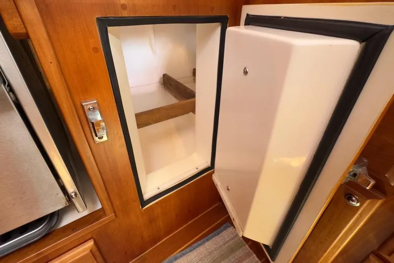 Finesse Yacht Photos Pics Open storage compartment in 2005 Sabre 386 yacht interior, featuring wooden finish and secure latch.