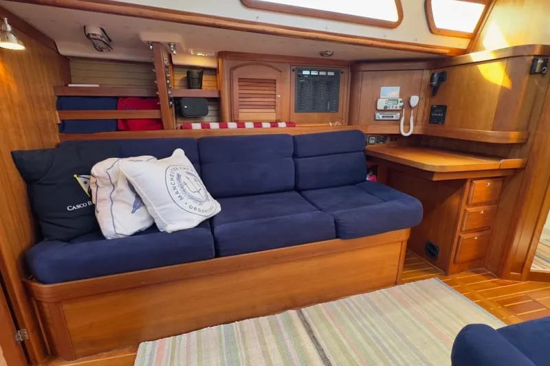 Finesse Yacht Photos Pics Interior of 2005 Sabre 386 sailboat with blue cushioned seating and wooden cabinetry.