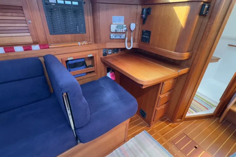 Finesse Yacht Photos Pics Interior of 2005 Sabre 386 yacht with wooden desk and blue seating.