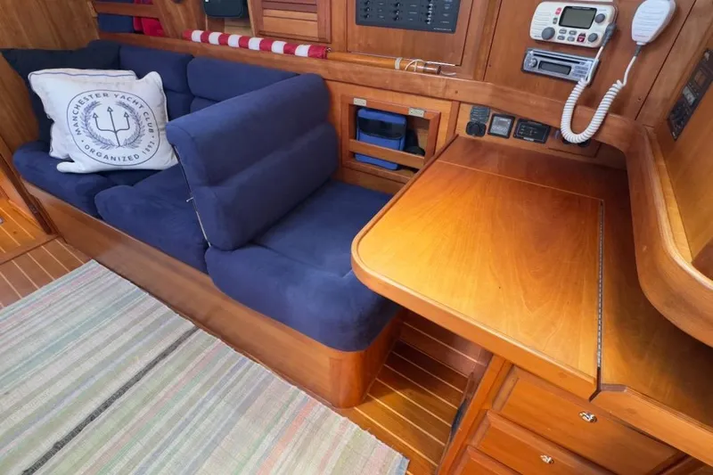 Finesse Yacht Photos Pics Interior of 2005 Sabre 386 yacht with blue sofa, wooden desk, and communication equipment.