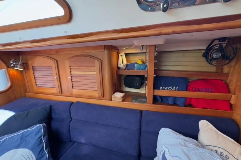 Finesse Yacht Photos Pics Interior of 2005 Sabre 386 yacht with blue seating and wooden cabinetry.
