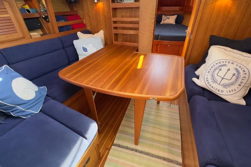 Finesse Yacht Photos Pics Interior of 2005 Sabre 386 yacht with wooden table and blue seating.