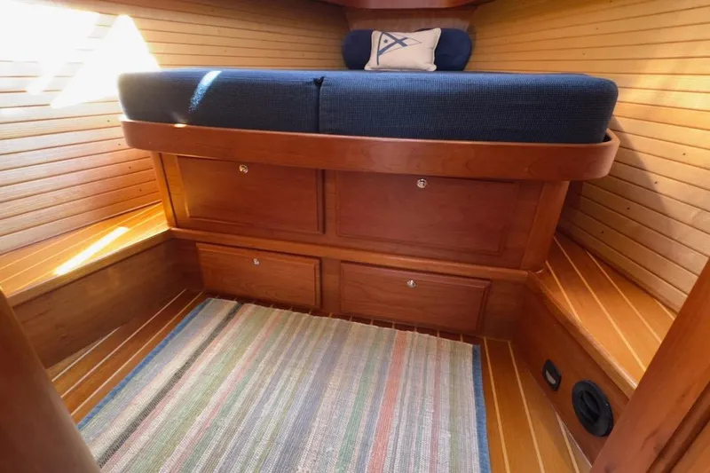 Finesse Yacht Photos Pics Cozy cabin interior of 2005 Sabre 386 sailboat with wooden finish and striped rug.