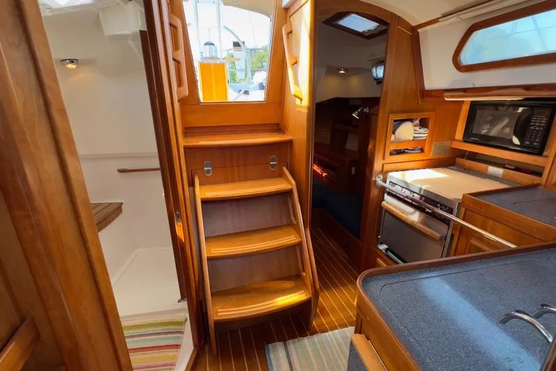 Finesse Yacht Photos Pics Interior of 2005 Sabre 386 sailboat with wooden cabinetry and compact kitchen area.