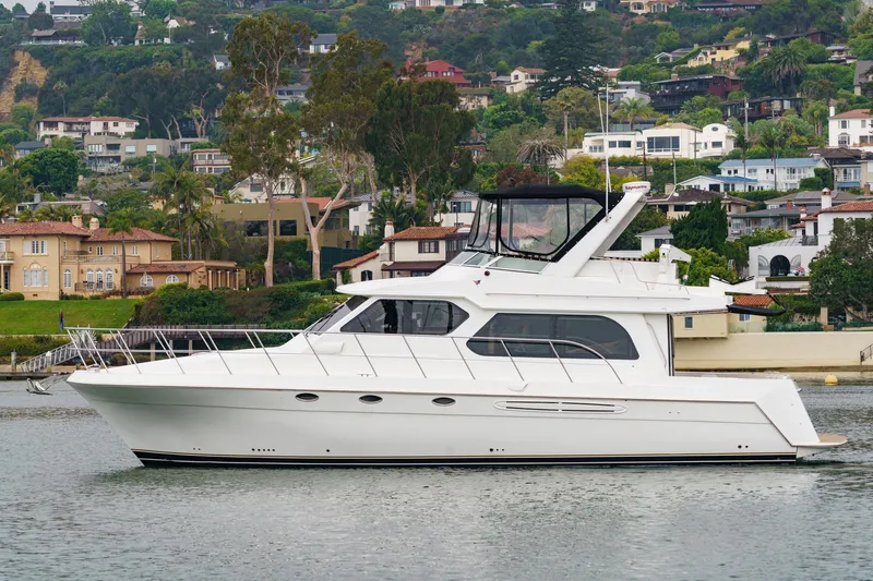 Carrin G Yacht Photos Pics 2008 Navigator 4600 Pilothouse yacht cruising near scenic waterfront homes.