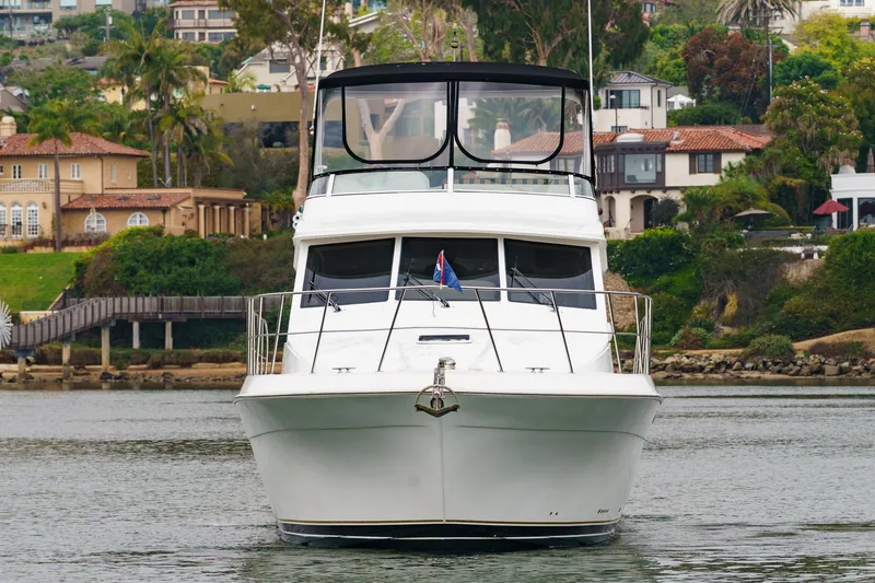 Carrin G Yacht Photos Pics 2008 Navigator 4600 Pilothouse yacht on calm water, with scenic waterfront homes.