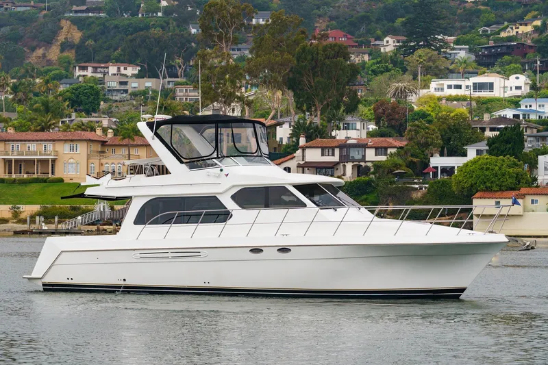 Carrin G Yacht Photos Pics 2008 Navigator 4600 Pilothouse yacht cruising near scenic waterfront homes.