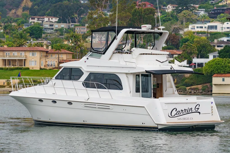 Carrin G Yacht Photos Pics 2008 Navigator 4600 Pilothouse yacht on calm water near luxury homes.