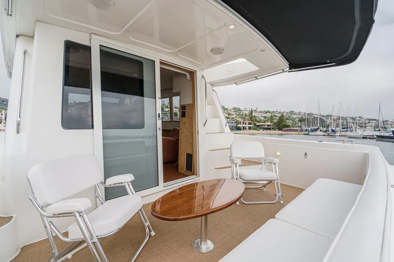Carrin G Yacht Photos Pics 2008 Navigator 4600 Pilothouse yacht deck with seating and table, overlooking marina.