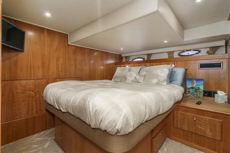 Carrin G Yacht Photos Pics Luxurious bedroom interior of 2008 Navigator 4600 Pilothouse yacht with wood paneling and cozy bedding.