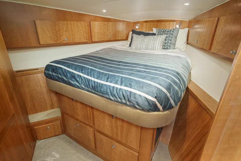 Carrin G Yacht Photos Pics Luxurious bedroom in 2008 Navigator 4600 Pilothouse yacht with wood cabinetry and striped bedding.